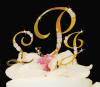 close-up of gold-plate monogram wedding cake topper