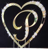 close up of single letter with single heart wedding cake topper