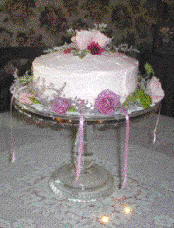 A bridesmaid charm cake with the cake charms under the cake - notice the ribbons around the bottom of the cake